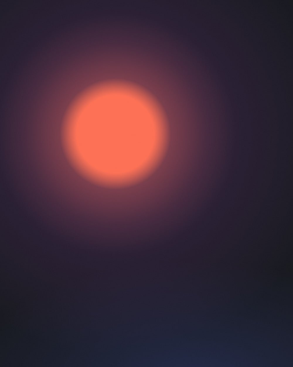 A large glowing coral orb with a soft magenta halo floats left of center on a deep charcoal field, with a faint blue light rising from the bottom edge.