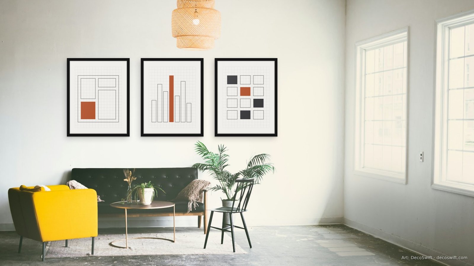 Video call background: Two large Linen Grid prints in thin black frames with wide white mats on a plain white wall, above a white counter stool and a potted snake plant, with a bright window at the right.