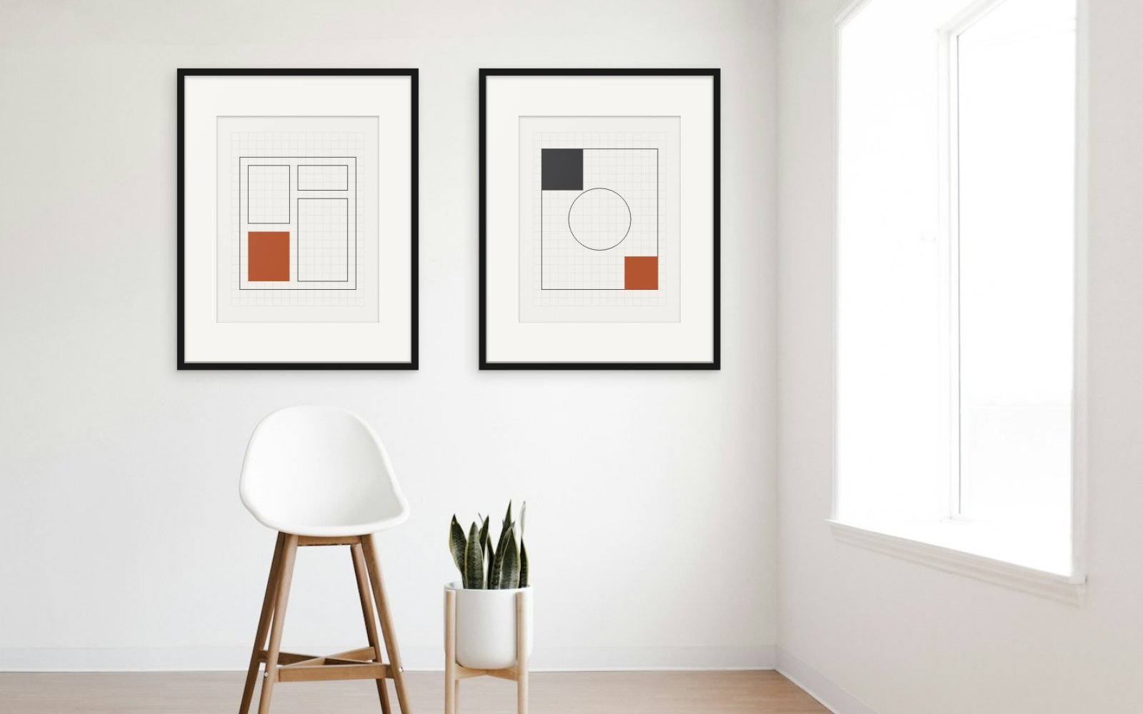 Two large Linen Grid prints in thin black frames with wide white mats on a plain white wall, above a white counter stool and a potted snake plant, with a bright window at the right.